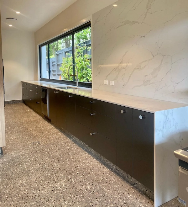 Dark cabinetry and marble splashback in a butler's pantry