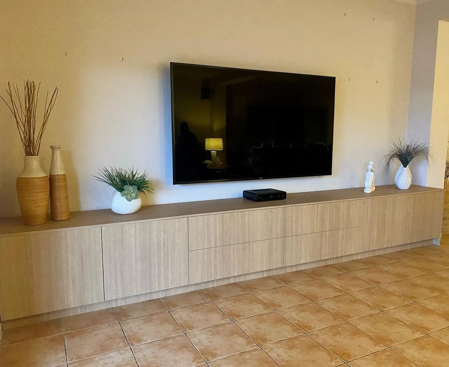 Long low wood-grained cabinetry beneath a wall-mounted television