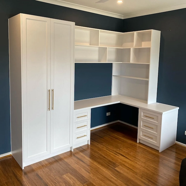 White built-in wardrobe and corner desk with open shelving in a home office