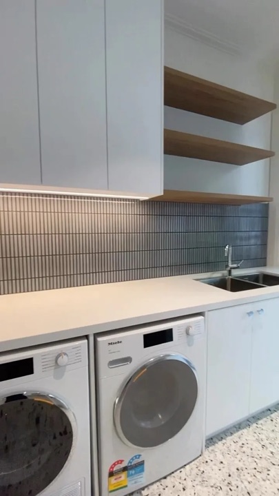 White overhead cabinets and open shelves above two appliances